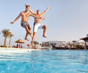 two men jumping into a pool